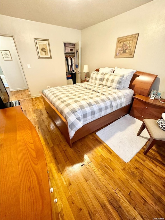 bedroom featuring hardwood / wood-style floors, a walk in closet, and a closet