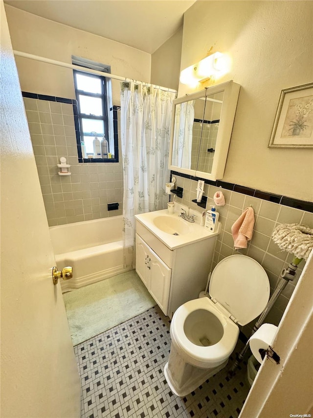 bathroom with tile patterned flooring, shower / bath combination with curtain, vanity, and tile walls