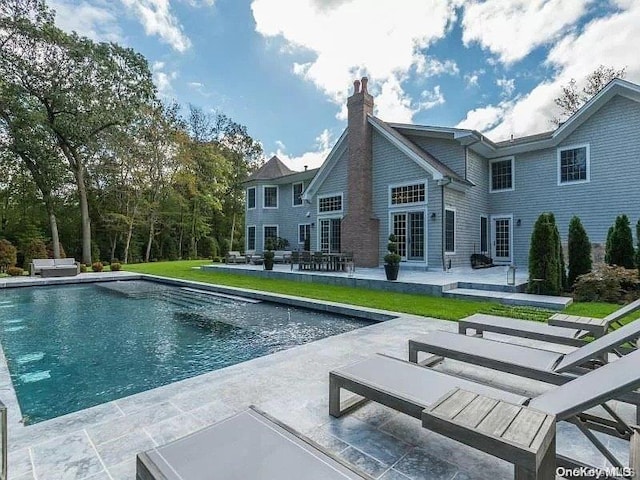 rear view of property with a patio area and a lawn