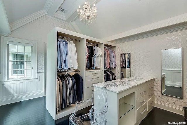 spacious closet featuring lofted ceiling with beams, dark hardwood / wood-style flooring, and an inviting chandelier