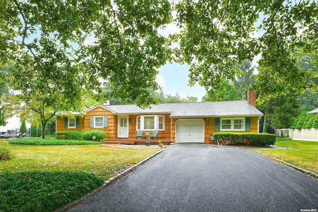 single story home featuring a front lawn and a garage