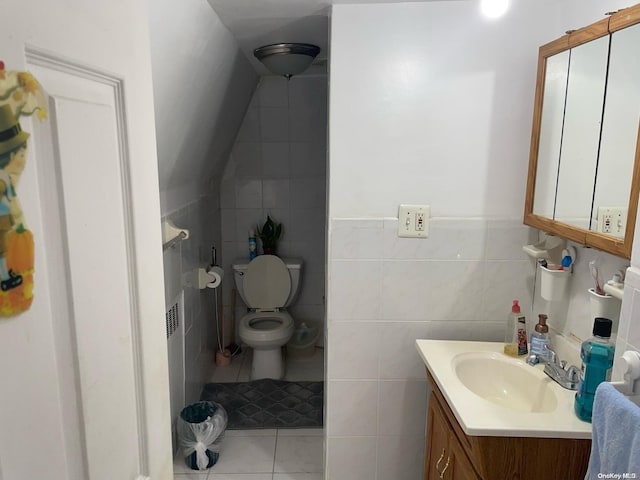 bathroom with tile patterned floors, vanity, toilet, and tile walls