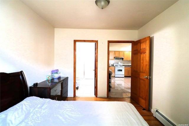 bedroom with light wood-type flooring and a baseboard radiator