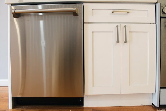 room details featuring dishwasher, white cabinets, and dark wood-type flooring