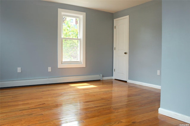 unfurnished room with light wood-type flooring and a baseboard radiator