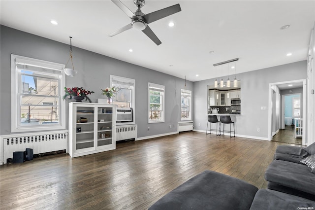 living room with ceiling fan, radiator heating unit, and dark hardwood / wood-style floors