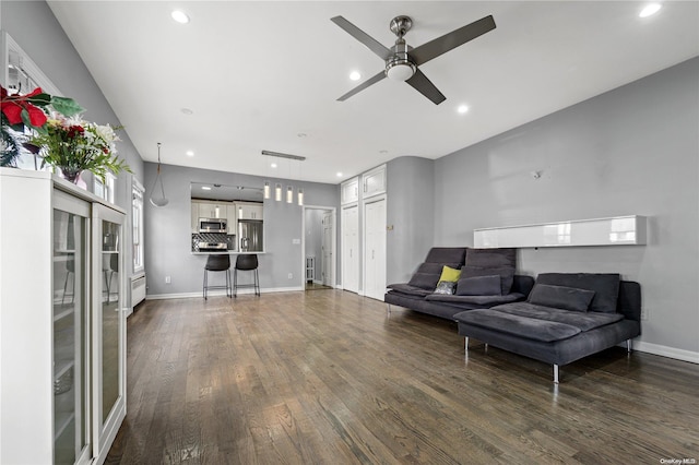 living room with dark wood-type flooring and ceiling fan