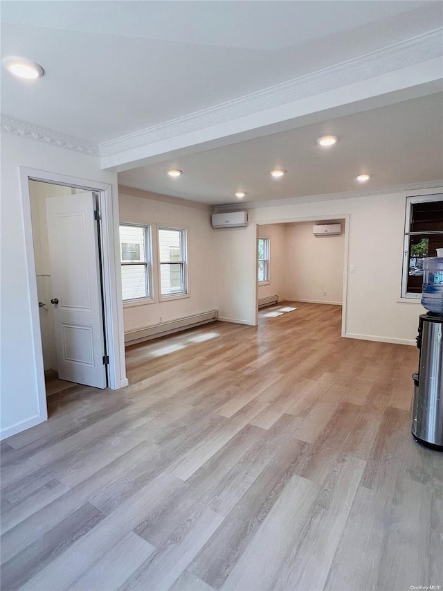 unfurnished living room featuring ornamental molding, light wood-type flooring, a wall unit AC, and a baseboard heating unit