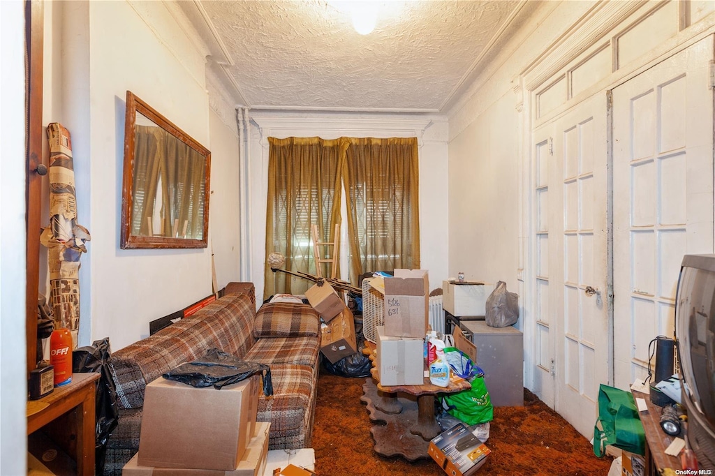 interior space with carpet flooring, a textured ceiling, and crown molding