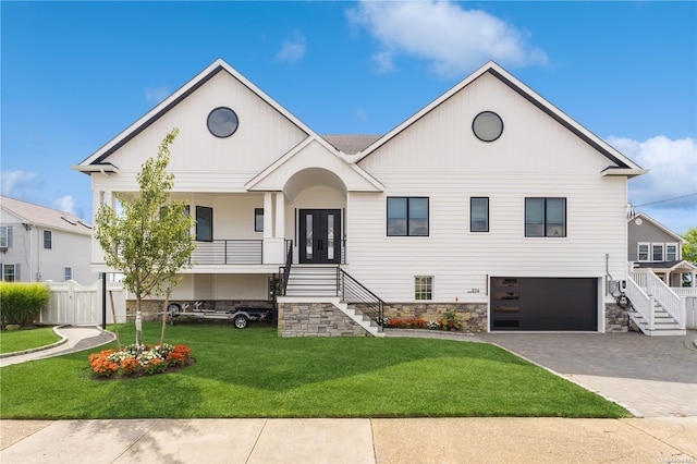 view of front of home with a front yard, french doors, and a garage