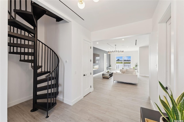 stairway featuring a notable chandelier and hardwood / wood-style flooring