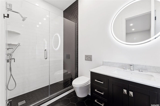 bathroom featuring tile patterned floors, vanity, toilet, and a shower with door