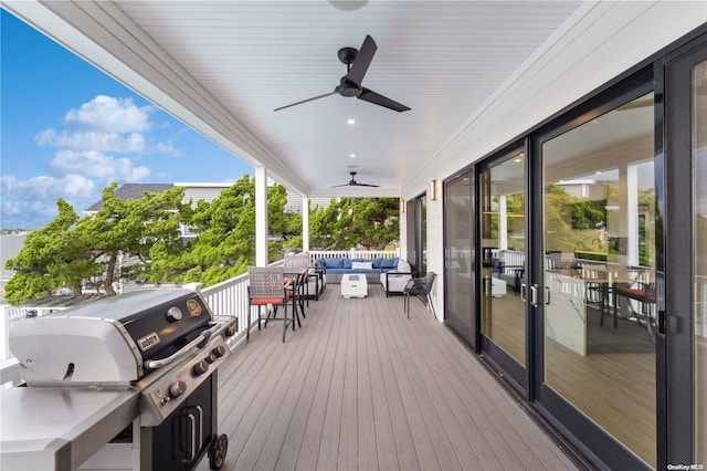 wooden terrace featuring an outdoor living space, ceiling fan, and a grill