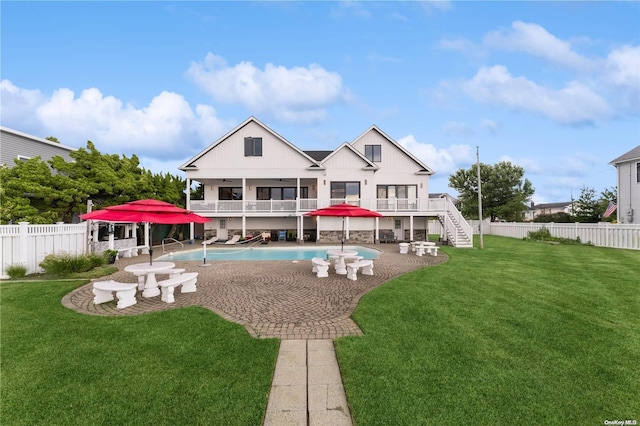 back of property with a fenced in pool, a yard, a balcony, and a patio