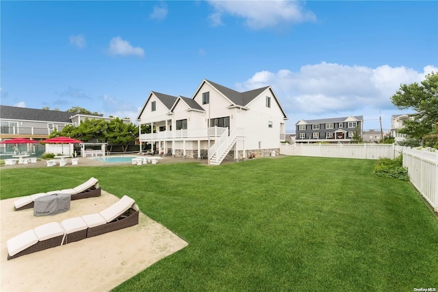 rear view of house with a lawn, a fenced in pool, and a patio