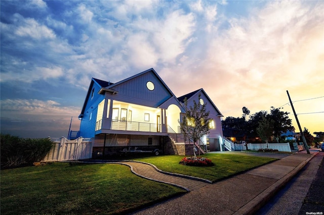 view of front of house with a yard and a balcony