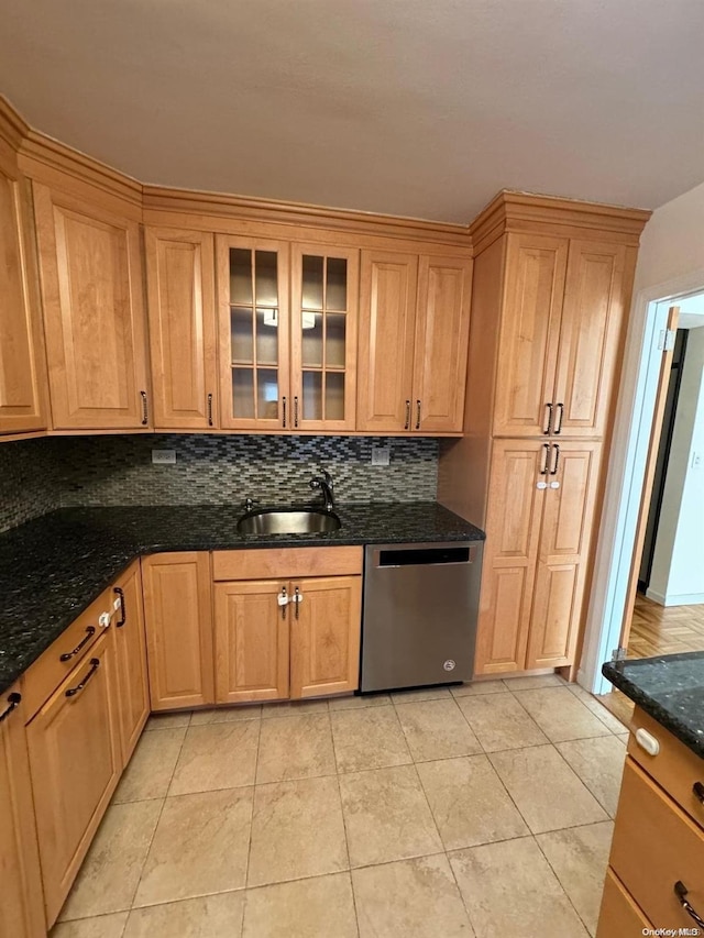 kitchen with dishwasher, sink, dark stone countertops, decorative backsplash, and light tile patterned floors