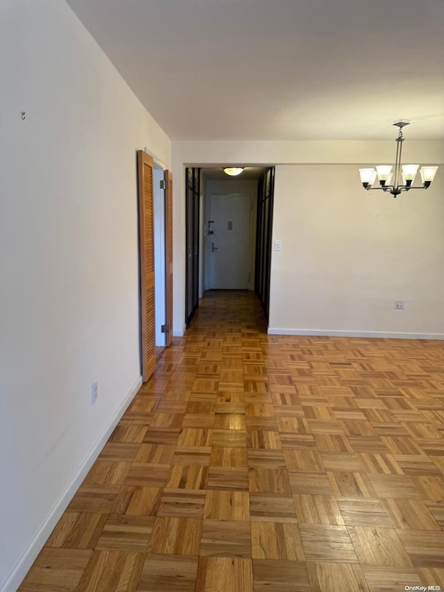 hallway featuring light parquet floors and a notable chandelier