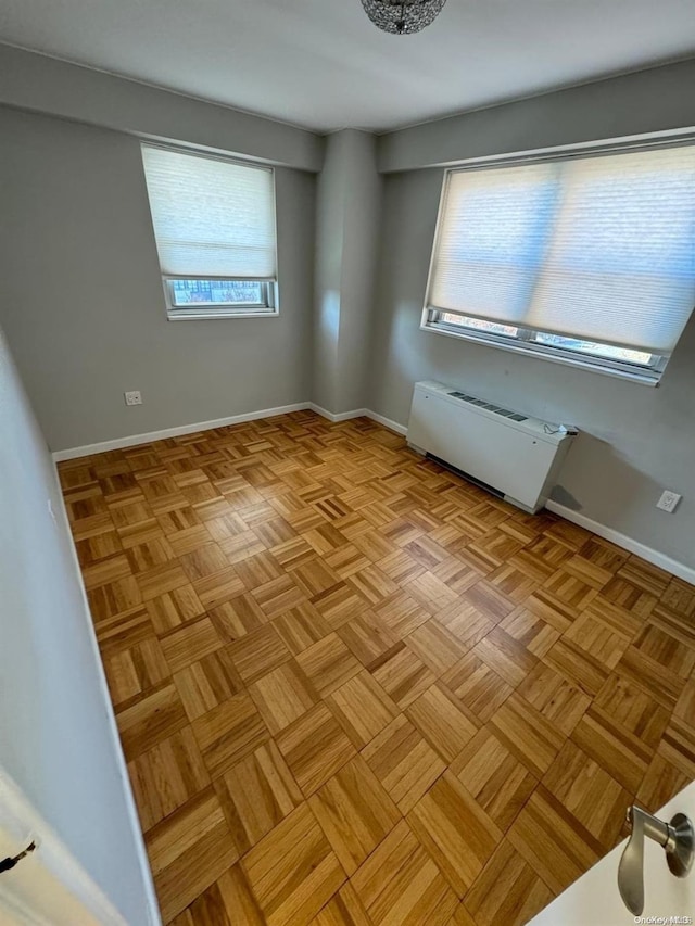 unfurnished room featuring a healthy amount of sunlight and light parquet flooring