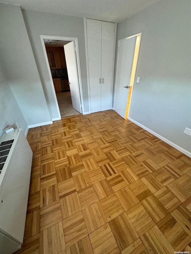 unfurnished bedroom with a closet and light parquet floors