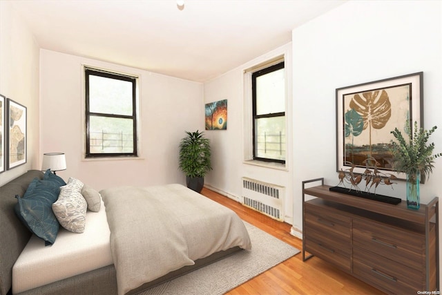 bedroom with hardwood / wood-style floors and radiator heating unit