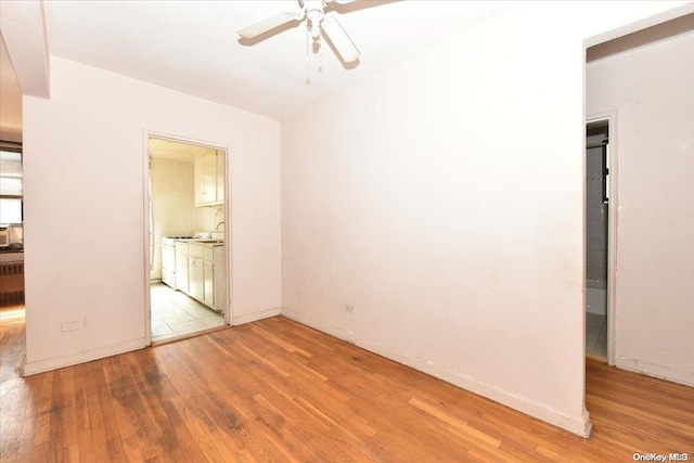 empty room with light hardwood / wood-style flooring and ceiling fan