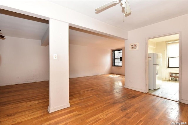 empty room with hardwood / wood-style floors and ceiling fan