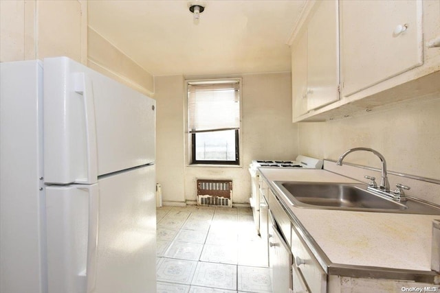 kitchen featuring sink, white cabinets, light tile patterned flooring, and white appliances