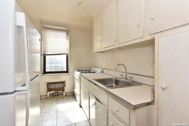 kitchen featuring white cabinets, white appliances, light tile patterned flooring, and sink