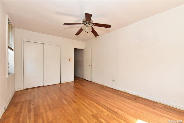 unfurnished bedroom with ceiling fan, a closet, and light wood-type flooring