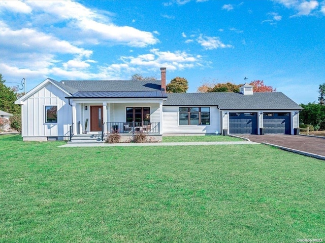 view of front of house featuring a front yard, a porch, and a garage