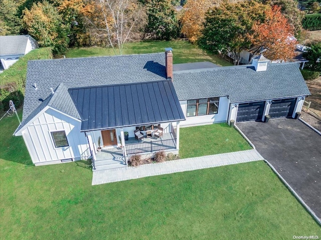 modern farmhouse featuring a garage, a standing seam roof, and roof with shingles