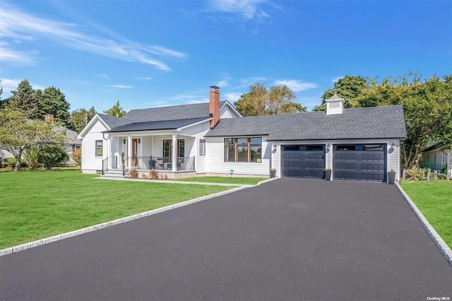 single story home featuring a front lawn, covered porch, and a garage