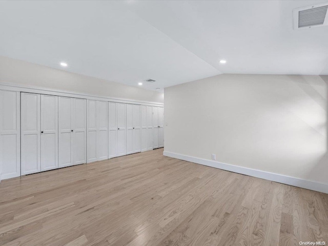 interior space with light hardwood / wood-style floors and vaulted ceiling