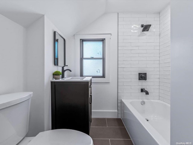 full bathroom with vanity, tiled shower / bath combo, vaulted ceiling, tile patterned flooring, and toilet