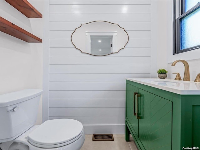 bathroom featuring vanity, toilet, and wood walls