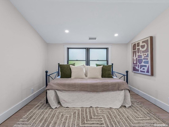 bedroom featuring hardwood / wood-style floors and lofted ceiling