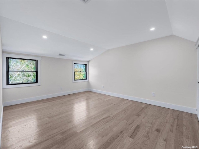 unfurnished room with light hardwood / wood-style flooring and vaulted ceiling