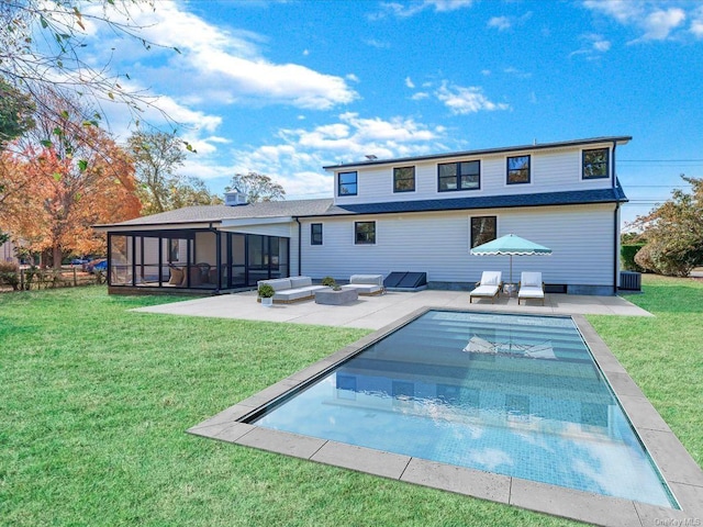 back of property featuring a sunroom, a patio area, and a lawn