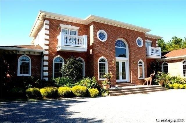 view of front facade with french doors and a balcony