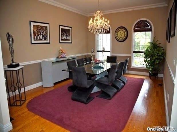 dining space featuring a chandelier, light hardwood / wood-style floors, and ornamental molding