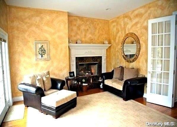 sitting room featuring hardwood / wood-style floors and a high end fireplace