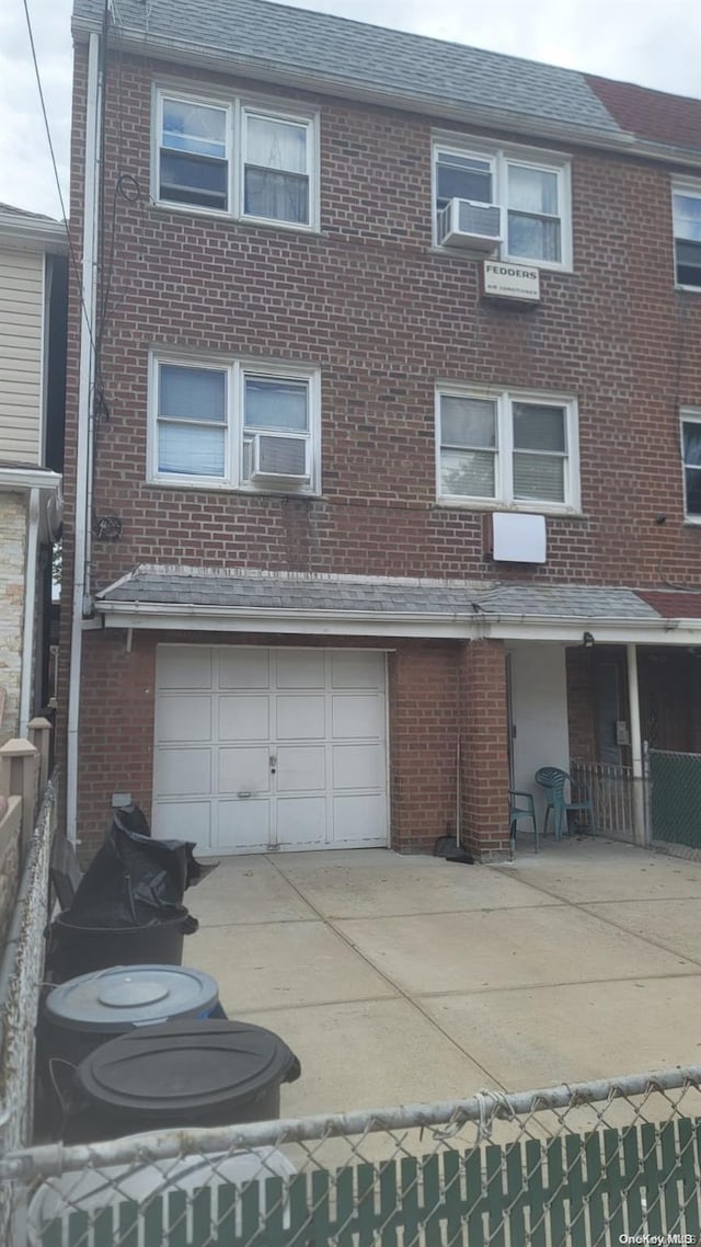 view of front of property featuring cooling unit and a garage