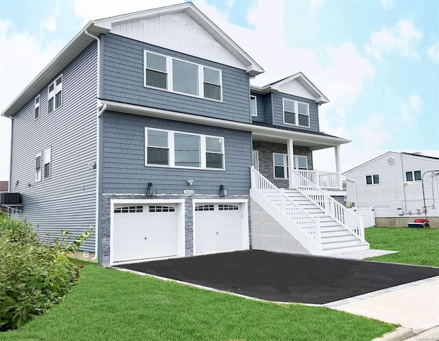 view of front of home featuring covered porch, a front yard, and a garage