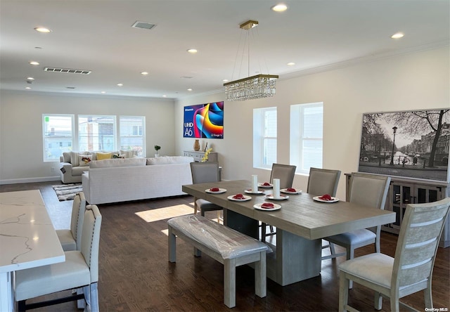 dining room with dark hardwood / wood-style flooring, ornamental molding, and an inviting chandelier