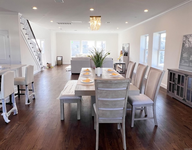 dining space featuring dark hardwood / wood-style floors, an inviting chandelier, and ornamental molding