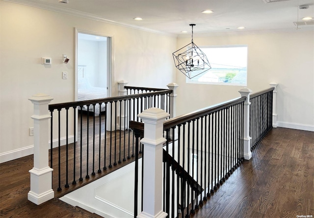 corridor with a chandelier, crown molding, and dark wood-type flooring