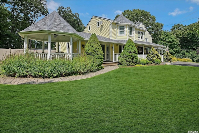 victorian house featuring a front lawn and covered porch