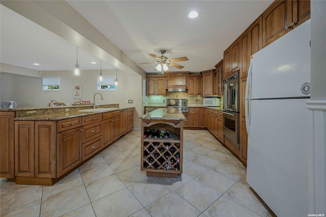 kitchen featuring light stone countertops, a center island, sink, hanging light fixtures, and stainless steel appliances