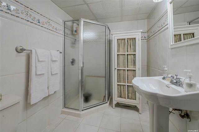 bathroom featuring tile patterned floors, toilet, and walk in shower